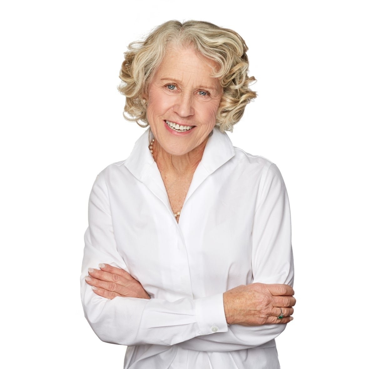 dr-ainslie-gray A woman in a white blouse smiles at the camera. Her arms are crossed.