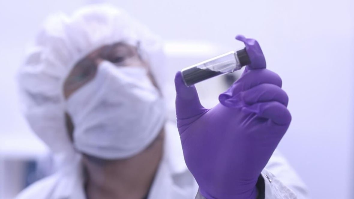 jason-dworkin-1 Man with purple glove holds up vial with black powder in it