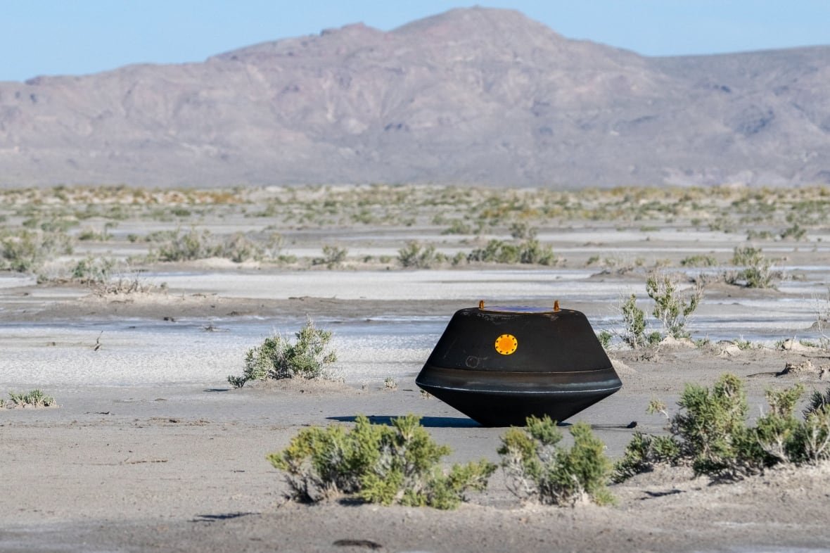 osiris-rex-sample-return Black capsule in the desert with mountains in background