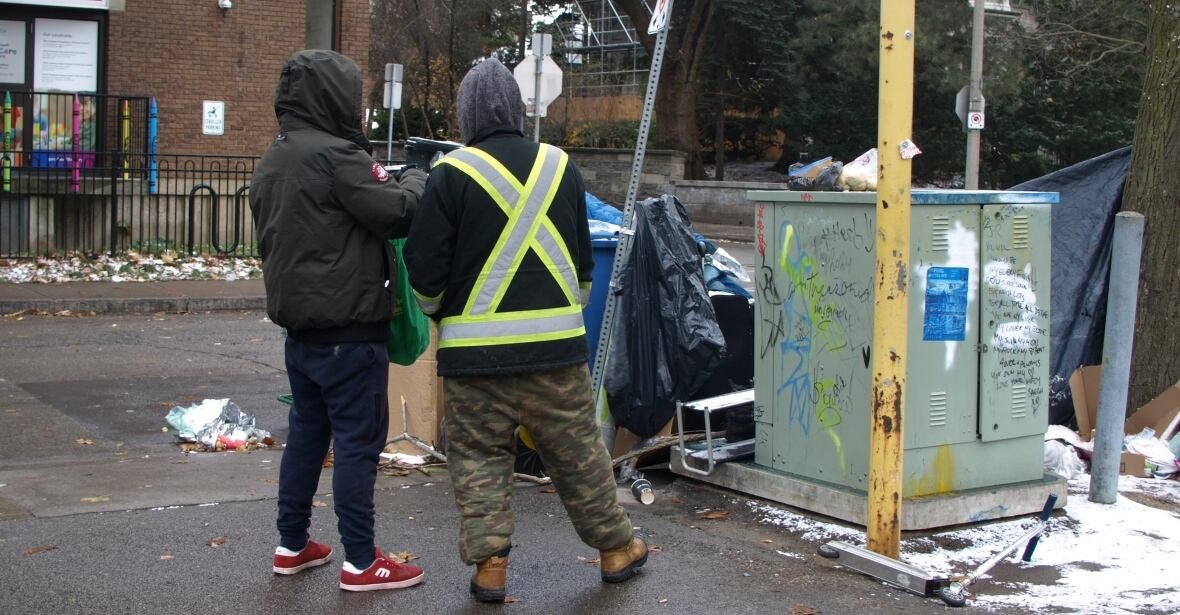 shelter-opinion Two men are pictured from behind.