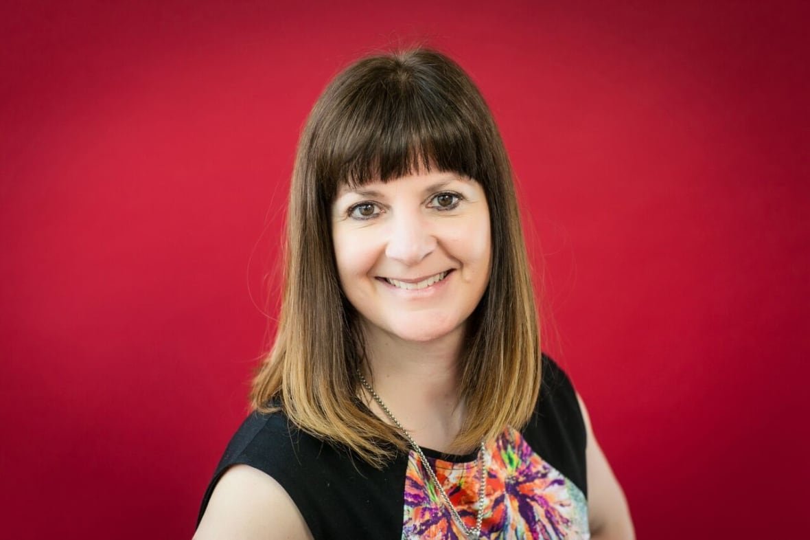stephanie-koonar A headshot of a woman, smiling for the camera, against a red background.