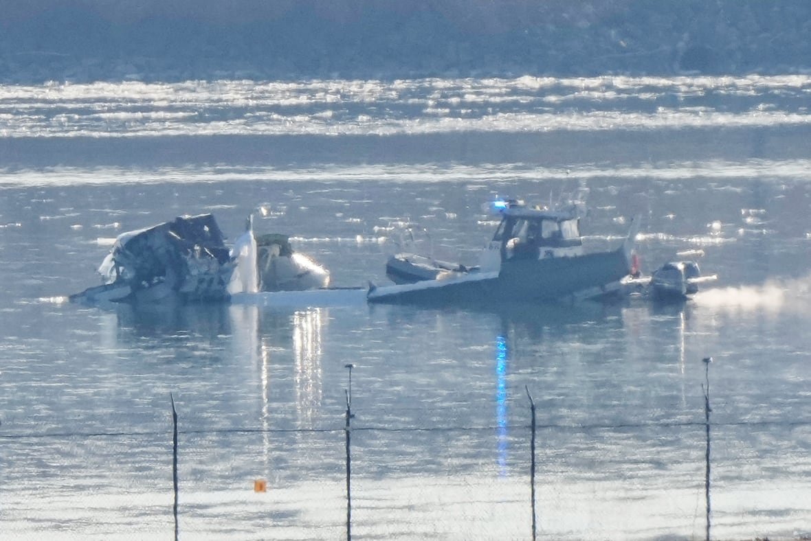 aircraft-down-1 A small boat is shown in a body of water, near to fusillage wreckage.