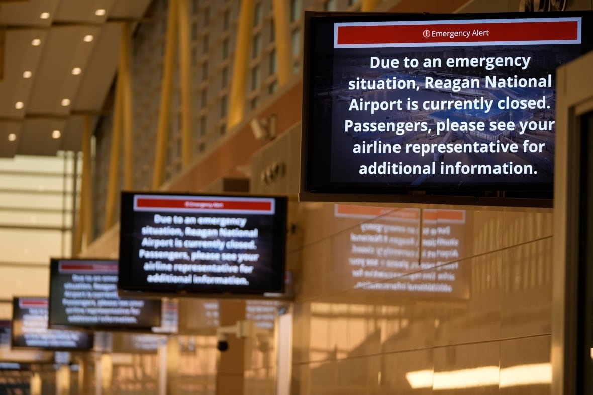 aircraft-down-2 Television screens are shown in an airport terminal with the message 'Due to an emergency situation, Reagan National Airport is currently closed.