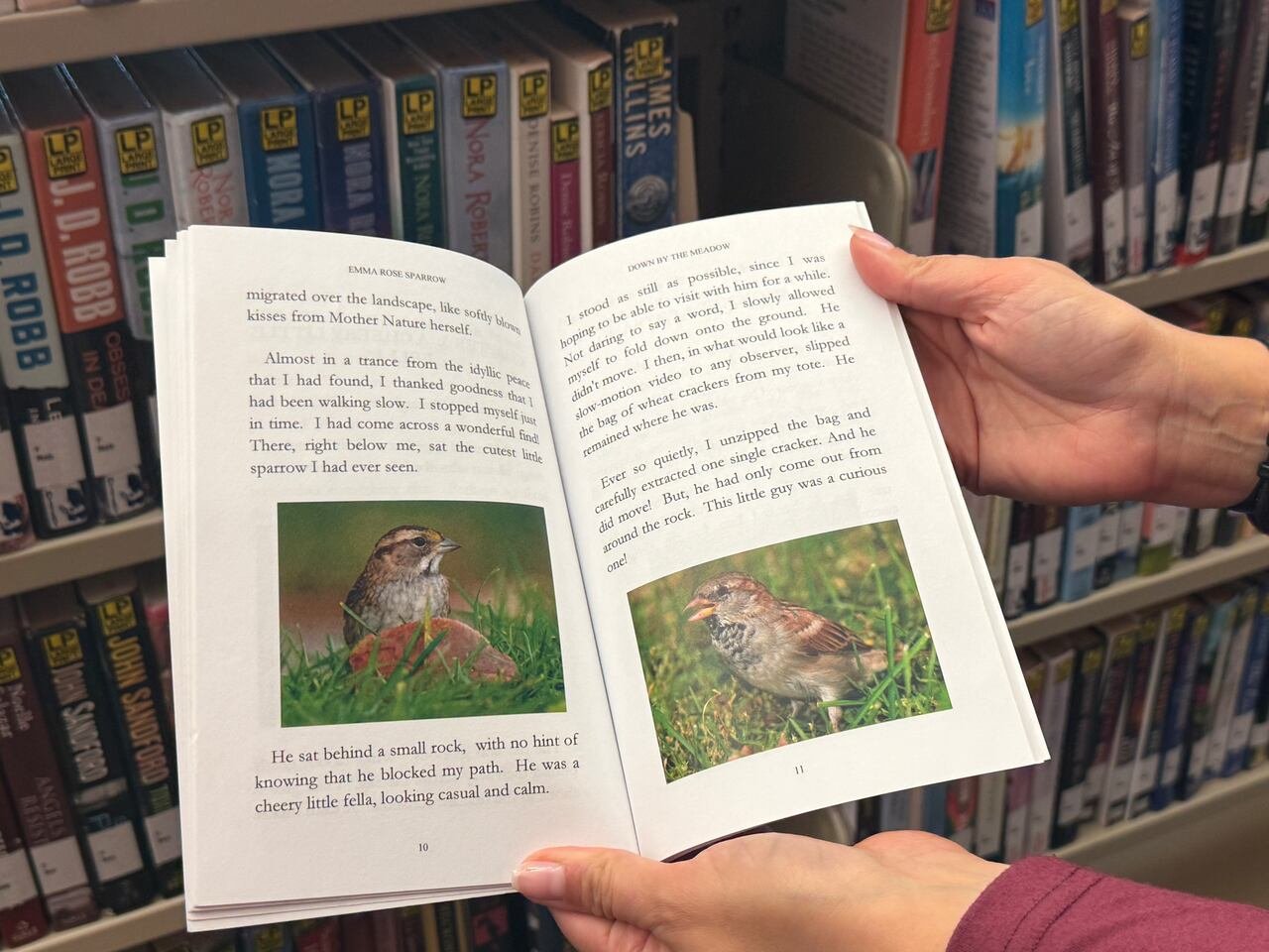 default-536 A woman holding a dementia-friendly book with large text and nature pictures.