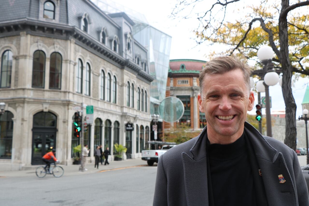 A man stands smiling at the camera