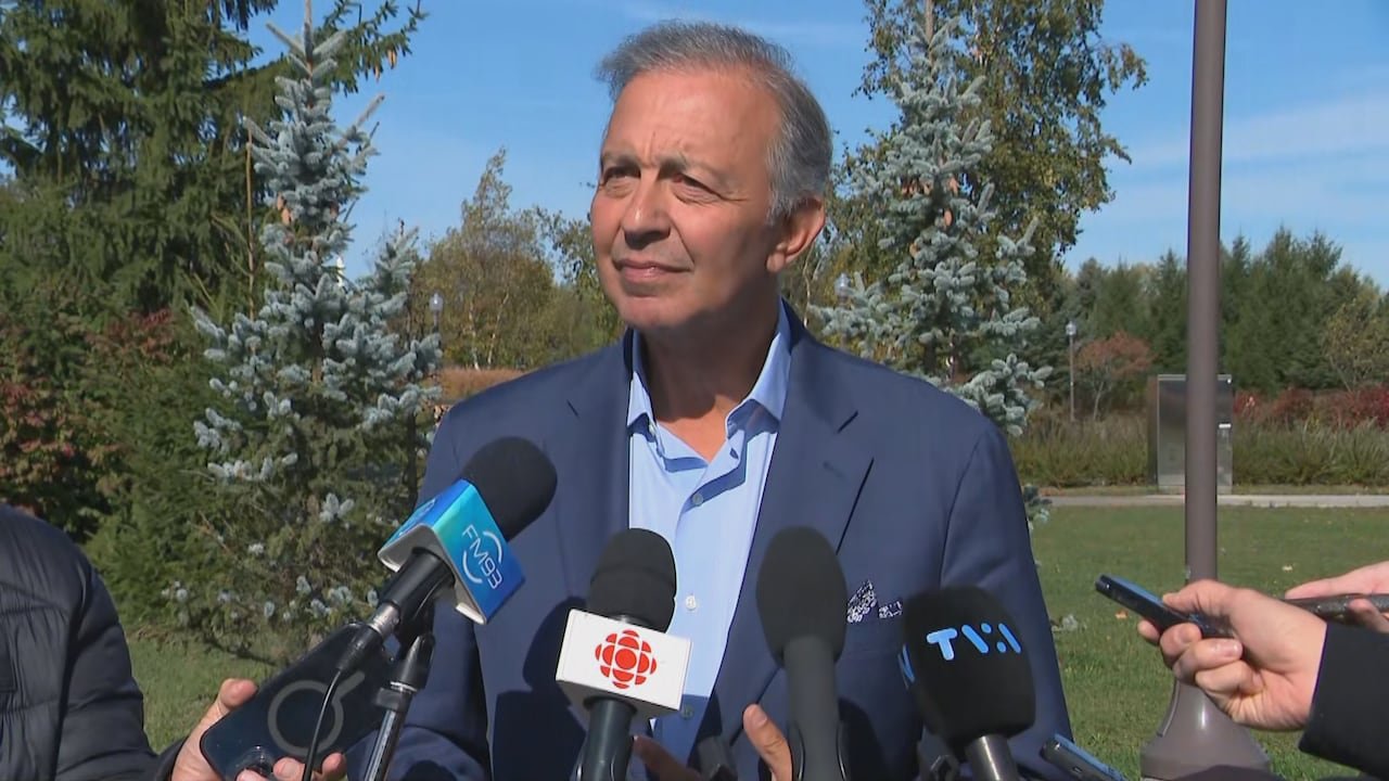 A man stands in front of microphones